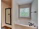 This is a bathroom with a soaking tub and a view to a black framed shower stall at 147 Tara Blvd, Loganville, GA 30052
