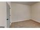 This is a neutral bedroom with tan carpet and light colored walls and trim and a door at 147 Tara Blvd, Loganville, GA 30052