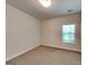 This is a neutral bedroom with tan carpet and light colored walls and trim and a window at 147 Tara Blvd, Loganville, GA 30052