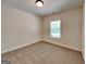 This is a neutral bedroom with tan carpet and light colored walls and trim and a window at 147 Tara Blvd, Loganville, GA 30052