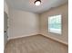This is a neutral bedroom with tan carpet and light colored walls and trim and a window at 147 Tara Blvd, Loganville, GA 30052