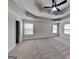 Spacious bedroom with tray ceiling, ceiling fan, three windows and plush carpet at 147 Tara Blvd, Loganville, GA 30052
