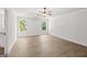 Spacious bedroom features a tray ceiling, ceiling fan, wood-look flooring, and bright, natural light from large windows at 3209 Broadnax Mill Rd # 6, Loganville, GA 30052