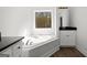 Bright bathroom with garden tub under window, modern fixtures and black countertop vanity at 3219 Broadnax Mill Rd # 5, Loganville, GA 30052