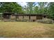 Spacious backyard featuring a stone and wood exterior, complemented by a lush green lawn at 5493 Alexanders Lake Sw Rd, Stockbridge, GA 30281