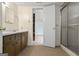 Neutral toned bathroom features a single sink vanity, with a tile floor, and shower visible through a doorway at 5493 Alexanders Lake Sw Rd, Stockbridge, GA 30281