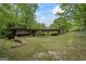 Charming single-story home with a stone facade, wood accents, and a covered carport surrounded by lush greenery at 5493 Alexanders Lake Sw Rd, Stockbridge, GA 30281