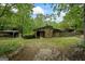 Charming single-story home with a stone facade, wood accents, and a covered storage building surrounded by lush greenery at 5493 Alexanders Lake Sw Rd, Stockbridge, GA 30281