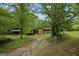 Inviting single-story home with stone and wood siding, complemented by mature trees and a covered carport at 5493 Alexanders Lake Sw Rd, Stockbridge, GA 30281