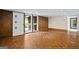 An open living space featuring wood-style flooring, wood paneling, and a sliding door to an outdoor area at 5493 Alexanders Lake Sw Rd, Stockbridge, GA 30281