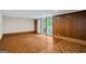 An empty living space with wood-style flooring, wood paneling, and a sliding door to an outdoor area at 5493 Alexanders Lake Sw Rd, Stockbridge, GA 30281