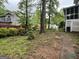 Large backyard with mature trees, a brick path, and a picnic table, perfect for outdoor activities at 332 Wyngate Rd, Auburn, GA 30011
