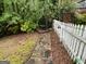 Backyard view with a stone path leading to a wooden swing, bordered by a white picket fence at 332 Wyngate Rd, Auburn, GA 30011