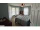 Cozy bedroom featuring a patterned quilt, carpeted floors, and sun-filled windows with white curtains at 332 Wyngate Rd, Auburn, GA 30011