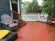 Inviting outdoor deck area with a colorful Adirondack chair, steps and a white picket fence at 332 Wyngate Rd, Auburn, GA 30011