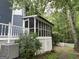 Screened porch with lattice detail on a blue home, offering an outdoor entertaining space at 332 Wyngate Rd, Auburn, GA 30011