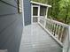 Relaxing screened porch with gray wood floors and white railing, perfect for enjoying the outdoors at 332 Wyngate Rd, Auburn, GA 30011