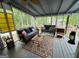 Cozy screened porch featuring comfortable seating and a view of the surrounding greenery at 332 Wyngate Rd, Auburn, GA 30011