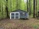 Exterior of shed with double doors and one window; located on wooded lot at 332 Wyngate Rd, Auburn, GA 30011
