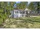 Quaint home with manicured front lawn, a welcoming porch, and a driveway, nestled among mature trees at 1858 Ridgeland Dr, Decatur, GA 30032