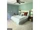 Bedroom features neutral carpet, a ceiling fan, and a comfortable bed with decorative pillows at 160 Hialeah Way, Roswell, GA 30075