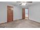Neutral bedroom featuring a ceiling fan, plush carpet and two doors at 930 Singley Dr, Locust Grove, GA 30248