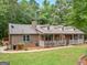 This brick home offers a long porch, and a well-kept lawn for outdoor enjoyment at 930 Singley Dr, Locust Grove, GA 30248