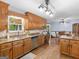 Well-lit kitchen featuring granite countertops, stainless steel sink and appliances, and wood cabinets at 930 Singley Dr, Locust Grove, GA 30248