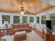 Sunroom featuring wood paneling, large windows, and a comfortable leather sofa at 930 Singley Dr, Locust Grove, GA 30248