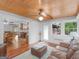 Sunroom with a view to the kitchen and featuring a wood ceiling, a leather sofa, and a decorative fan at 930 Singley Dr, Locust Grove, GA 30248