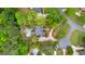 Aerial view of a home nestled among lush trees, showcasing its pool, backyard, driveway, and surrounding landscape at 105 Riviera Ct, Fayetteville, GA 30215