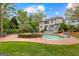Large backyard with mature trees features an in-ground pool with waterfall feature at 105 Riviera Ct, Fayetteville, GA 30215