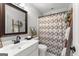 Traditional bathroom with a white vanity, decorative mirror, and patterned shower curtain at 105 Riviera Ct, Fayetteville, GA 30215