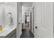 Hallway with black tiled floors leading to a bathroom with gray vanities at 105 Riviera Ct, Fayetteville, GA 30215