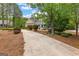 A grand home exterior is framed by manicured landscaping and a long driveway, highlighting the property's curb appeal at 105 Riviera Ct, Fayetteville, GA 30215