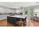 Bright kitchen features stainless appliances, gray cabinets, island with seating, and hardwood floors at 105 Riviera Ct, Fayetteville, GA 30215