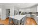 Bright kitchen features stainless appliances, gray cabinets, island with seating, and hardwood floors at 105 Riviera Ct, Fayetteville, GA 30215