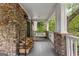 Inviting covered porch with a porch swing and stacked wood for the fireplace at 105 Riviera Ct, Fayetteville, GA 30215