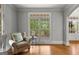Charming sitting room with a comfortable armchair, hardwood floors, and large windows overlooking a garden at 105 Riviera Ct, Fayetteville, GA 30215