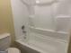 Bathroom featuring a white tub/shower combination with built-in shelving and a standard toilet at 8833 Thomas Rd, Jonesboro, GA 30238