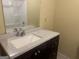 A bathroom features a vanity with a speckled granite countertop and a dark wood cabinet at 8833 Thomas Rd, Jonesboro, GA 30238