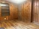 Bedroom with wood-paneled walls, hardwood floors, built-in shelves and a closet door at 8833 Thomas Rd, Jonesboro, GA 30238