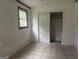 Bedroom features white walls, tile flooring, a standard closet, and a window at 8833 Thomas Rd, Jonesboro, GA 30238