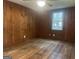 Wood-paneled bedroom featuring hardwood floors, a ceiling fan, and a window offering natural light at 8833 Thomas Rd, Jonesboro, GA 30238