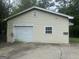 A detached garage with a roll-up door shows some wear, and is adjacent to the main home at 8833 Thomas Rd, Jonesboro, GA 30238