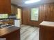 Wood-paneled kitchen with laminate floors and countertops, a window, and white appliances at 8833 Thomas Rd, Jonesboro, GA 30238