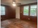 Spacious living room with wood-paneled walls, hardwood floors, a ceiling fan and bright natural light at 8833 Thomas Rd, Jonesboro, GA 30238