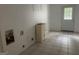 A room with tile flooring, white walls with plumbing connections, a small cabinet, and an exterior door at 8833 Thomas Rd, Jonesboro, GA 30238