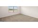 A carpeted bedroom with a window and an electric outlet at 572 Whitman Ln # 19, Stockbridge, GA 30281