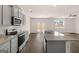 Modern kitchen featuring stainless steel appliances, gray cabinets, granite countertops, and a convenient island at 572 Whitman Ln # 19, Stockbridge, GA 30281